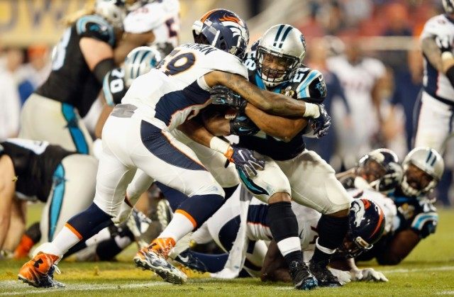 Jonathan Stewart (C-R) of the Carolina Panthers is tackled by Danny Trevathan of the Denve