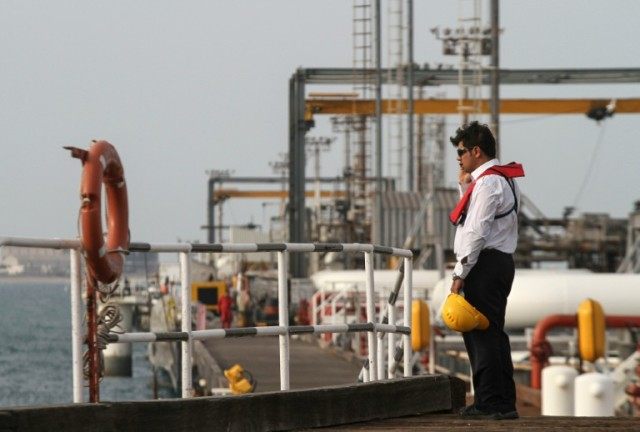 An Iranian technician stands at an oil facility in Khark Island, on the shores of the Gulf