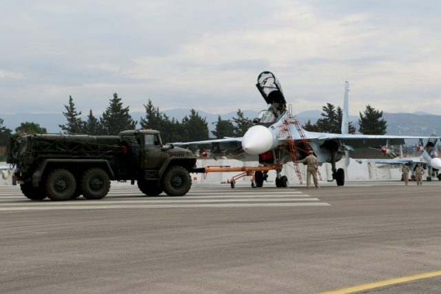 Russian servicemen prepare a Russian Sukhoi Su-30SM fighter jet before departure on a miss