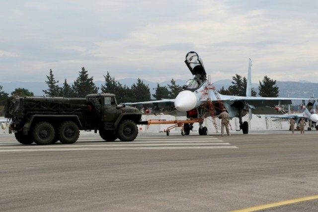Russian servicemen prepare a Russian Sukhoi Su-30SM fighter jet before departure on a miss