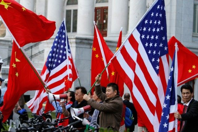 People wave Chinese and American flags in Washington, DC on April 1, 2016