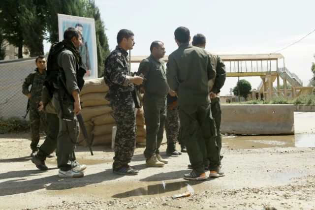 Kurdish police stand at a checkpoint where a suicide bomber killed five officers on April
