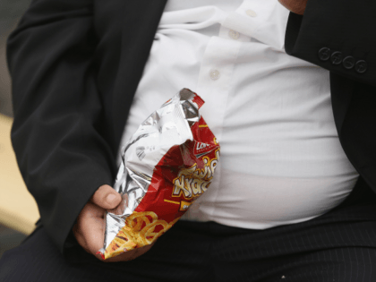 LEIPZIG, GERMANY - MAY 23: A man with a large belly eats junk food on May 23, 2013 in Leipzig, Germany. According to statistics a majority of Germans are overweight and are comparatively heavier than people in most other countries in Europe.