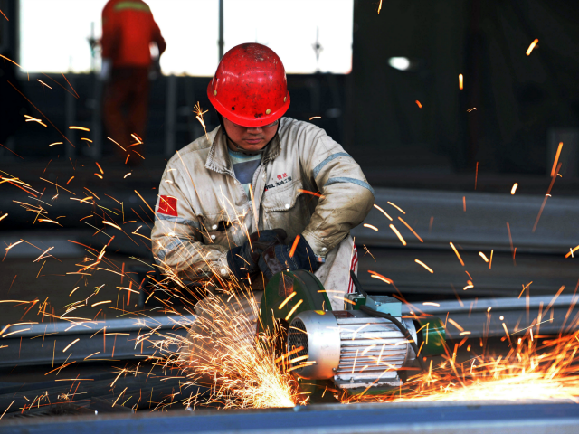 A worker polishing a piece of work at a structural steelworks company in Rizhao, eastern China Gett