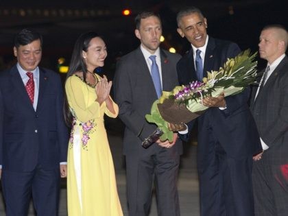 U.S. President Barack Obama is given flowers by Linh Tran, the ceremonial flower girl, as