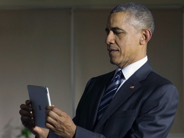 U.S. President Barack Obama uses an iPad as he tours the DreamPlex Coworking Space in Ho C