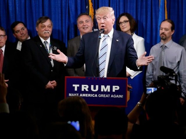 Republican presidential candidate Donald Trump, center, stands with some of the 22 delegat