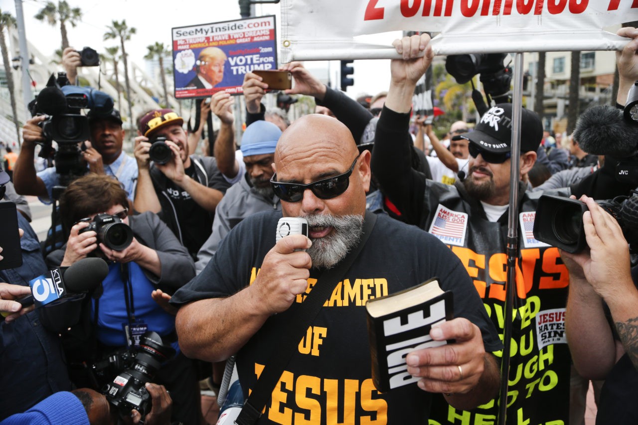 Pro-Trump speaker Ruben Israel points his bible at anti-Trump demonstratorsoutside the San Diego Convention Center where Republican presidential candidate Donald Trump was scheduled to speak, Friday, May 27, 2016, in San Diego. (AP Photo/Lenny Ignelzi)