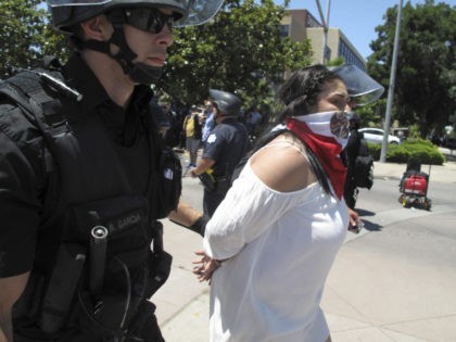 Police officers take a woman into custody after a Republican presidential candidate Donald Trump campaing rally in Fresno, Calif., on Friday, May 27, 2016. Police officers told hundreds of protesters to clear the streets in downtown Fresno following the Trump rally. Officers dressed in riot gear arrested two people on …