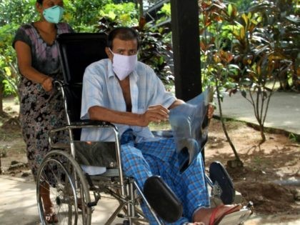 Carrying his X-ray result, a patient rides on a wheel chair at National Tuberculosis Refer