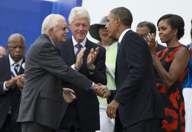 President Barack Obama shakes hands with former President Jimmy Carter, left, during a cer