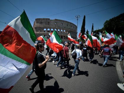 TOPSHOT - Members of Italian far-right political movement CasaPound march with Italian flags near the Colosseum during a demonstration on May 21, 2016 in Rome. AFP PHOTO / FILIPPO MONTEFORTE / AFP / FILIPPO MONTEFORTE (Photo credit should read FILIPPO MONTEFORTE/AFP/Getty Images)