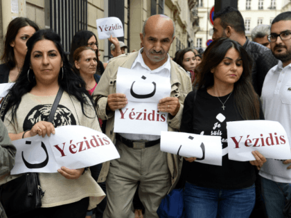 Demonstrators hold signs reading 'Yezidis' and the arabic letter 'N', which stands for Christian, as they take part on August 13, 2014 in a demonstration in support of the Yezidis and the Christians in Iraq, near the French Elysee presidential palace in Paris.