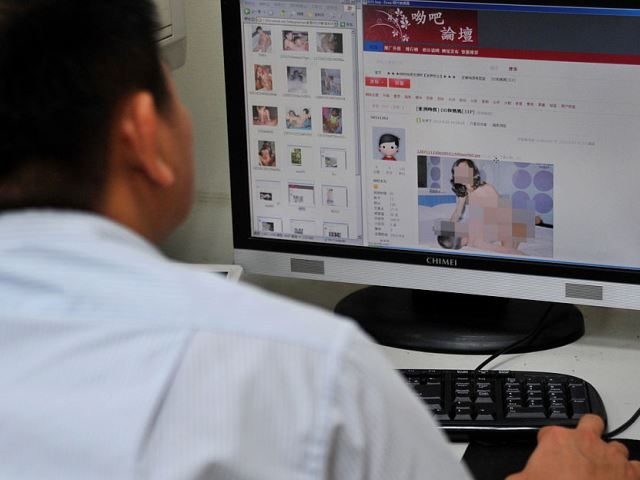 A staff member of the Criminal Investigation Bureau checks screen captures of child pornog