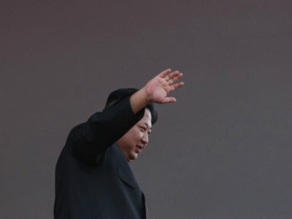 North Korea's leader Kim Jong-Un waves from a balcony towards participants of a mass