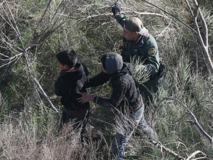 A Border Patrol agent leads juvenile undocumented immigrants after capturing them near the U.S.-Mexico border on December 10, 2015 at La Grulla, Texas.