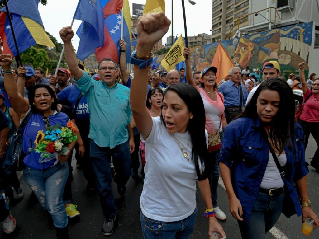 Members of the opposition of Venezuelan President Nicolas Maduro clash with riot police during a demonstration in Caracas on May 11, 2016. With helmets, shields and bulletproof, military and Venezuelan police vests prevented Wednesday the advance of thousands of opponents who tried to reach the headquarters of the National Electoral Council (CNE), to demand accelerate the process of a recall referendum against President Nicolas Maduro. / AFP / JUAN BARRETO (Photo credit should read JUAN BARRETO/AFP/Getty Images)