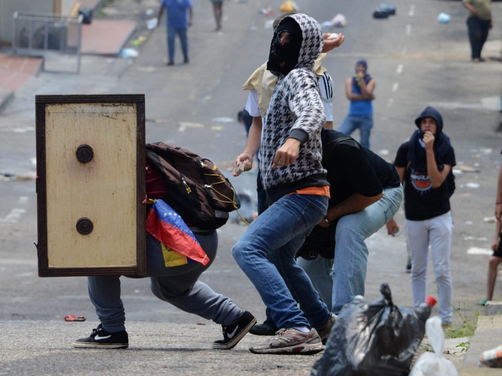 Venezuelan opposition activists clash with the police during a demonstration in San Cristobal, on May 11, 2016. Thousands of Venezuelan opposition took to the streets to demand the National Electoral Council (CNE) to accelerate the process of a recall referendum against President Nicolas Maduro. / AFP / George Castellanos (Photo credit should read GEORGE CASTELLANOS/AFP/Getty Images)