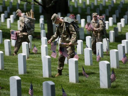 Members of the US Army place American flags at graves at Arlington National Cemetery May 2
