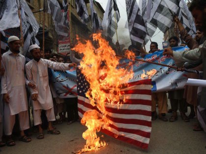 Pakistani supporters of the banned fundamentalist organisation Jamaat-ud-Dawa (JuD) burn a