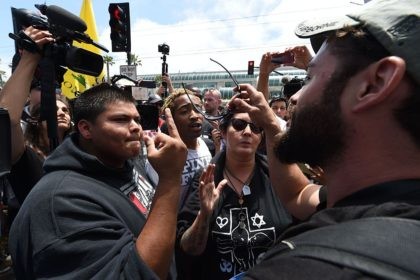 Anti-Trump protesters (L) and supporters argue outside a venue where republican presidenti