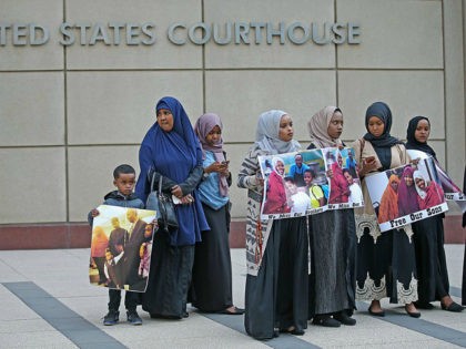 Supporters and family members of Somali men standing trial rally for a protest in front of