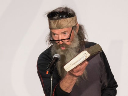 TV's Duck Dynasty star Phil Robertson holds up his Bible during a campaign rally for Republican presidential candidate Ted Cruz in Charleston, South Carolina, February 19, 2016. / AFP / JIM WATSON (Photo credit should read JIM WATSON/AFP/Getty Images)