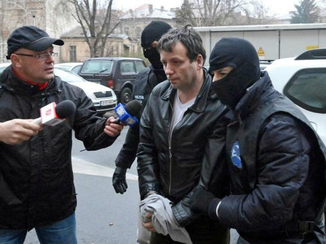 Marcel Lazar Lehel, 40, is escorted by masked policemen in Bucharest, after being arrested in Arad, 550 km (337 miles) west of Bucharest January 22, 2014. REUTERS/MEDIAFAX/SILVIU MATEI