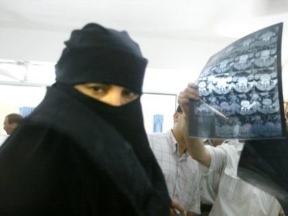 sick Palestinian woman wearing traditional clothing stands near German neurosurgeons who a