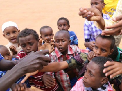 KENYA, DADAAB : DADAAB, KENYA - OCTOBER 12: This photo taken on October 4, 2014 shows refugee children reaching out for candies distributed by an African man at Dadaab refugee camp in Kenya, the largest refugee complex in the world, where thousands of Somalis, Tanzanians, Sudanese and Ethiopians fleeing conflicts …