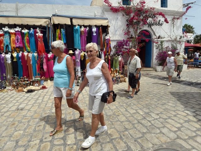 Tourists walk in the souk of Djerba on the Tunisian resort island on May 7, 2015.