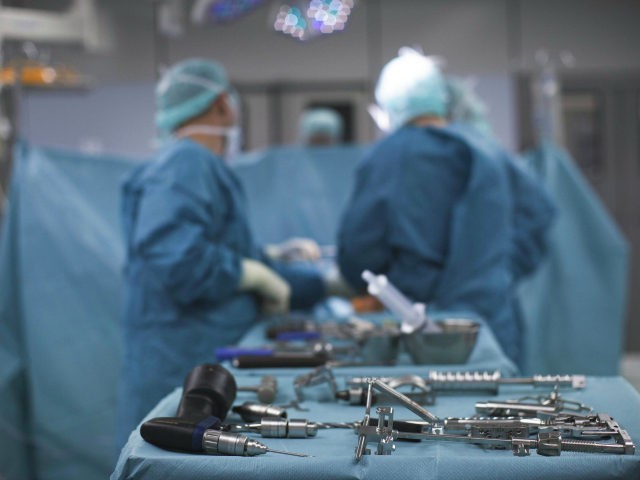 Doctors and medical staff work during knee prosthesis surgery in an operation room at the