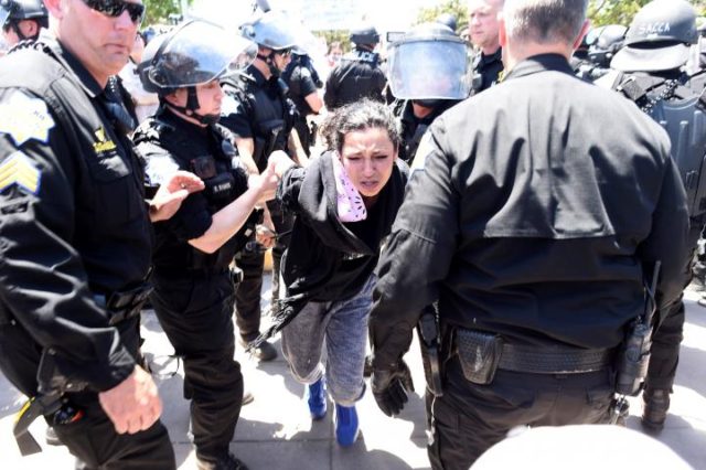 Police officers detain a protester following a rally for Republican U.S. presidential candidate Donald Trump in Fresno, California, U.S. May 27, 2016. REUTERS/Noah Berger