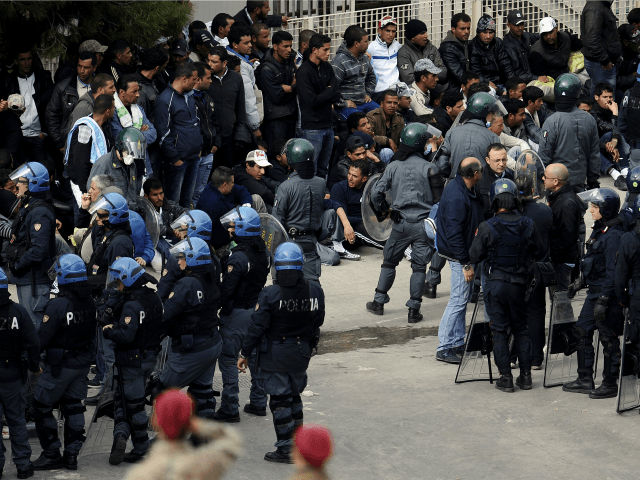 Police intervene to restore order in a temporary staying center, on the Italian island of Lampedusa, after migrants set fire and tried to escape, on April 11, 2011.