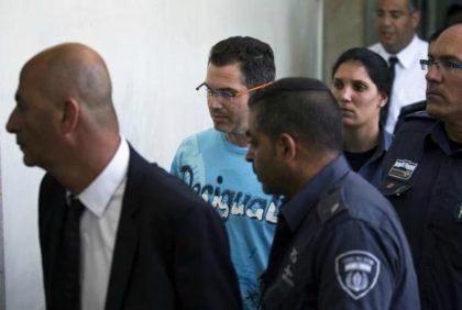 Ziv Orenstein (C), who is accused by U.S. authorities of engaging in a stock manipulation scheme involving U.S. penny stocks, arrives at a courtroom at the Jerusalem Magistrates Court July 22, 2015.