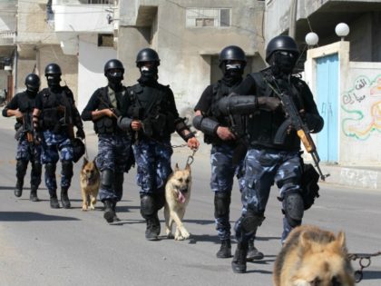 Palestinian Hamas policmen march with their police dogs along a street in Gaza City on April 24, 2013.