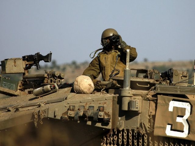 A picture taken from the Israeli-annexed Golan Heights shows an Israeli soldier monitoring