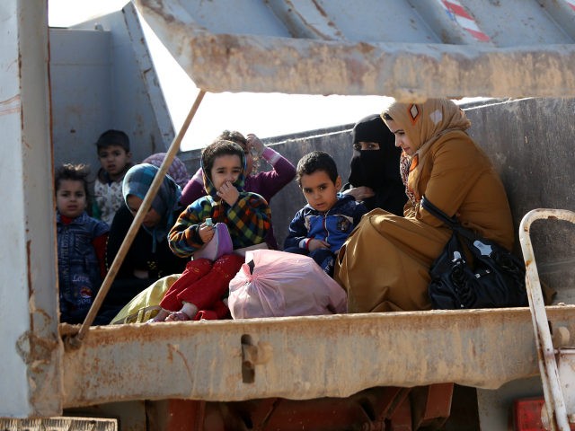 IRAQ, Karbala : Iraqi women and children, who fled Fallujah, sit in the back of a truck as they wait at an army checkpoint at Ayn al-Tamer crossing at the entrance to Karbala province on January 6, 2014. Buses and cars carrying families fleeing the fighting in Fallujah and Ramadi …
