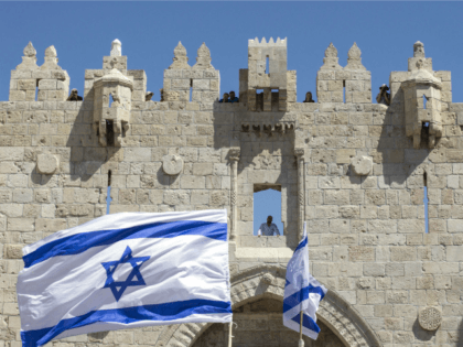 Israeli youths wave their national flag as they take part in the 'flag march' through Damascus Gate in Jerusalem's old city during celebrations for Jerusalem Day on May 17, 2015 which marks the anniversary of the 'reunification' of the holy city after Israel captured the Arab eastern sector from Jordan …