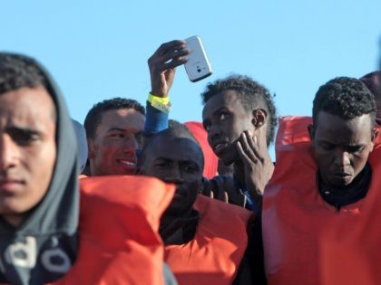 Migrants and refugees disembark from a Maltese coast guard patrol vessel after being rescued at sea, on April 15, 2016, at the Messina harbor in Sicily.