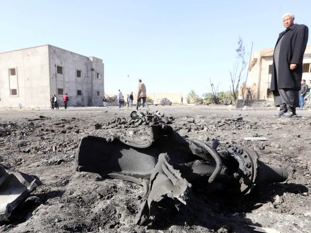 Libyans inspect the site of a suicide truck bombing on a police school in Libya's coa