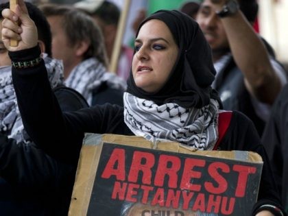 A pro-Palestinian demonstrator carrying a placard depicting Israeli Prime Minister Benjamin Netanyahu joins others during a protest outside the gates of Downing Street in London on September 9, 2015.