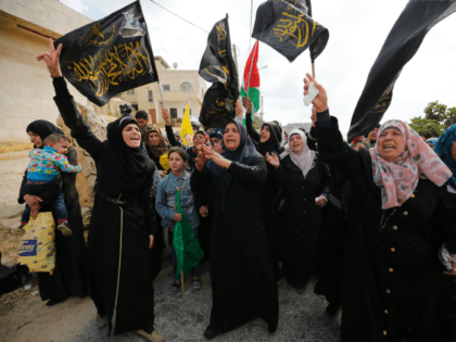 Palestinian mourners wave flags of the Palestinian Islamic Jihad movement in the West Bank village of Qatanna, on May 23, 2016, during the funeral of Maram Abu Ismail, 23, and her brother Ibrahim Taha, 16, who were shot dead by Israeli police last month at the Qalandiya checkpoint after attempting …