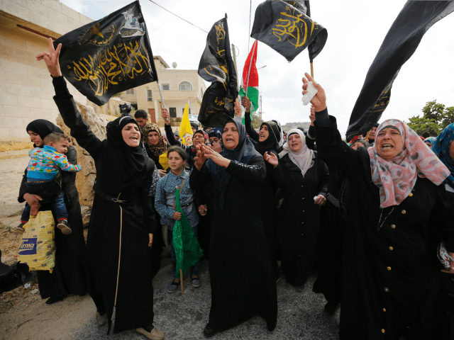 Palestinian mourners wave flags of the Palestinian Islamic Jihad movement in the West Bank