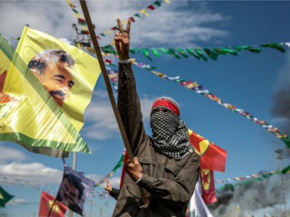 TURKEY, Diyarbakir : DIYARBAKIR, TURKEY - MARCH 21: A Kurdish man wearing a mask flashes the v-sign as he holds up a flag with a picture of the jailed PKK leader Abdullah Ocalan during Newroz celebrations, on March 21, 2015 in Diyarbakir, Turkey. Thousands of Kurds gather for the Newroz …