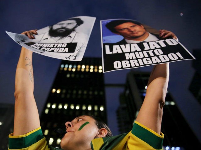 A demonstrator holds banners as she takes part in a protest against Brazil's President Dil