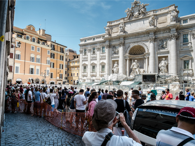Tourists gather next to the Trevi fountain under renovation in central Rome on July 27, 20