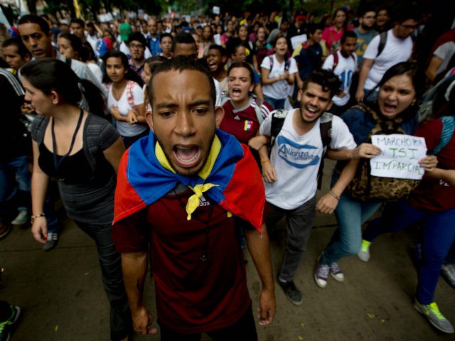 University students shout slogans against Venezuela's President Nicolas Maduro during a protest in Caracas, Venezuela, Thursday, May 26, 2016. The public university students marched to demand that the government provide more resources and avoid closing centers of study. (AP Photo/Fernando Llano)