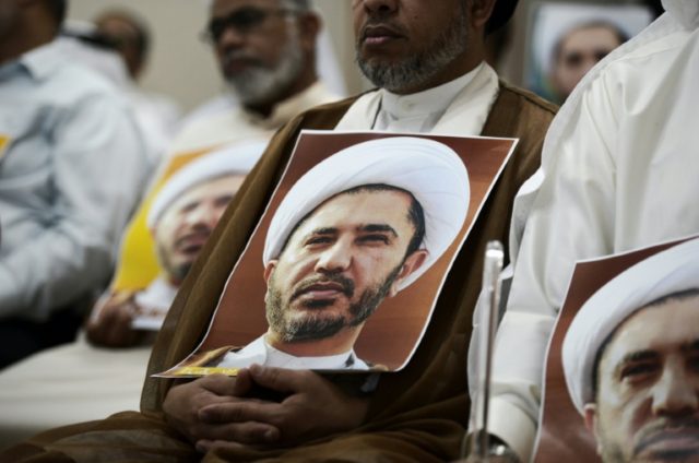 Bahraini men hold placards bearing the portrait of Sheikh Ali Salman, head of the Shiite o