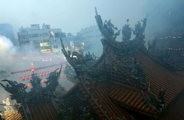 Heavy smoke billows from burnt offerings and incense at a Matzu temple during a Taoist cer